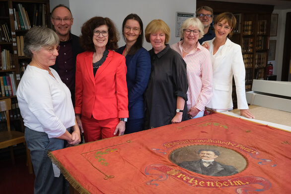 Vorstellung der neu restaurierten Lassalle-Fahne des Ortsvereins der SPD Mainz-Bretzenheim im Stadtarchiv mit Eva Brachert, Frank Teske, Sissi Westrich, Kathleen Herr, Kersten Autze-Gutte, Brigitte Erzgräber, Uwe Bergmann-Deppisch und Kulturdezernentin Marianne Grosse (Foto: Wolfgang Dobras)