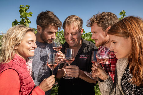 Eine Gruppe bei der Weinprobe im Weinberg.